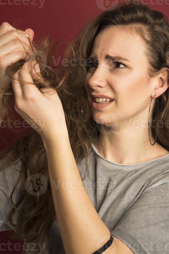 Damaged Hair. Beautiful Sad Young Woman With Long Disheveled Hair. Closeup Portrait Of Female Model Holding Messy Unbrushed Dry Hair In Hands. Hair Damage, Health And Beauty Concept. High Resolution photo