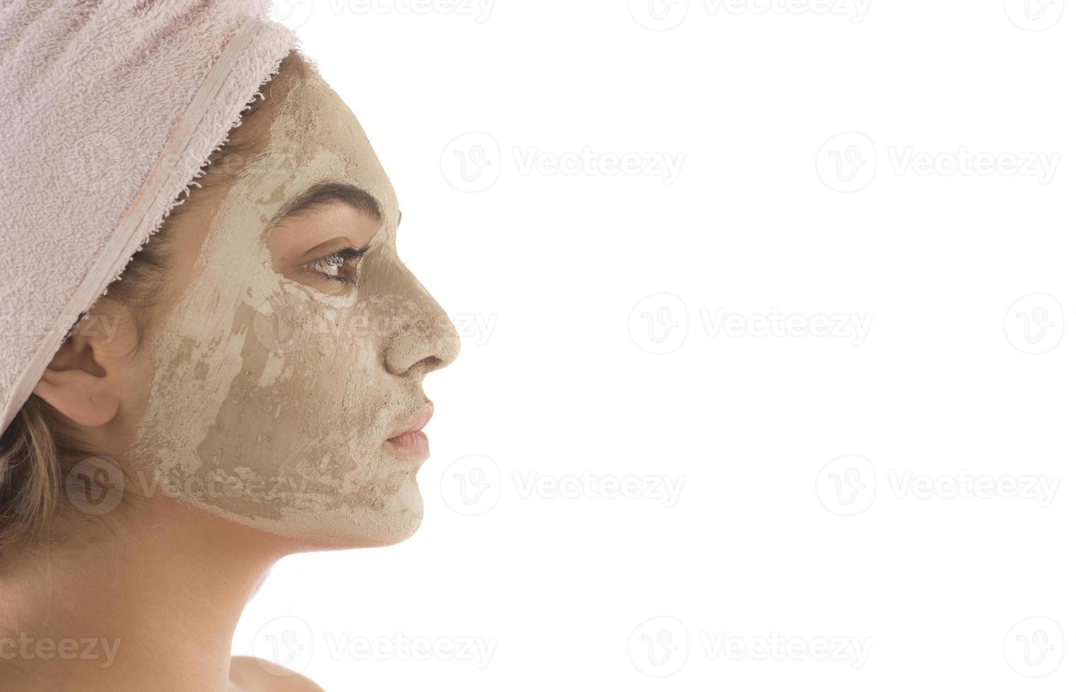 Beauty procedures skin care concept. Young woman applying facial mud clay mask to her face photo