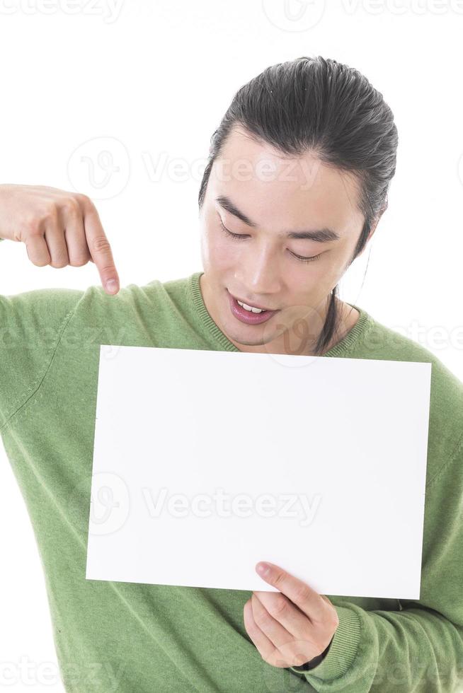 Handsome Asian man holding blank empty banner doing ok sign with fingers, smiling friendly photo