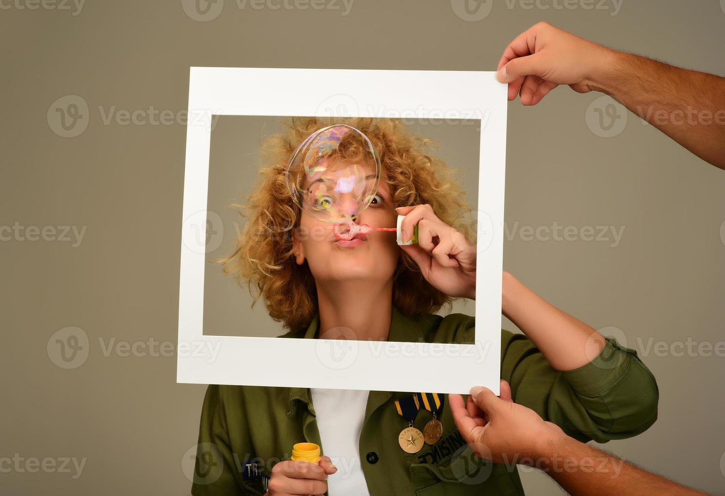 mujer en marco de imagen soplando burbujas foto