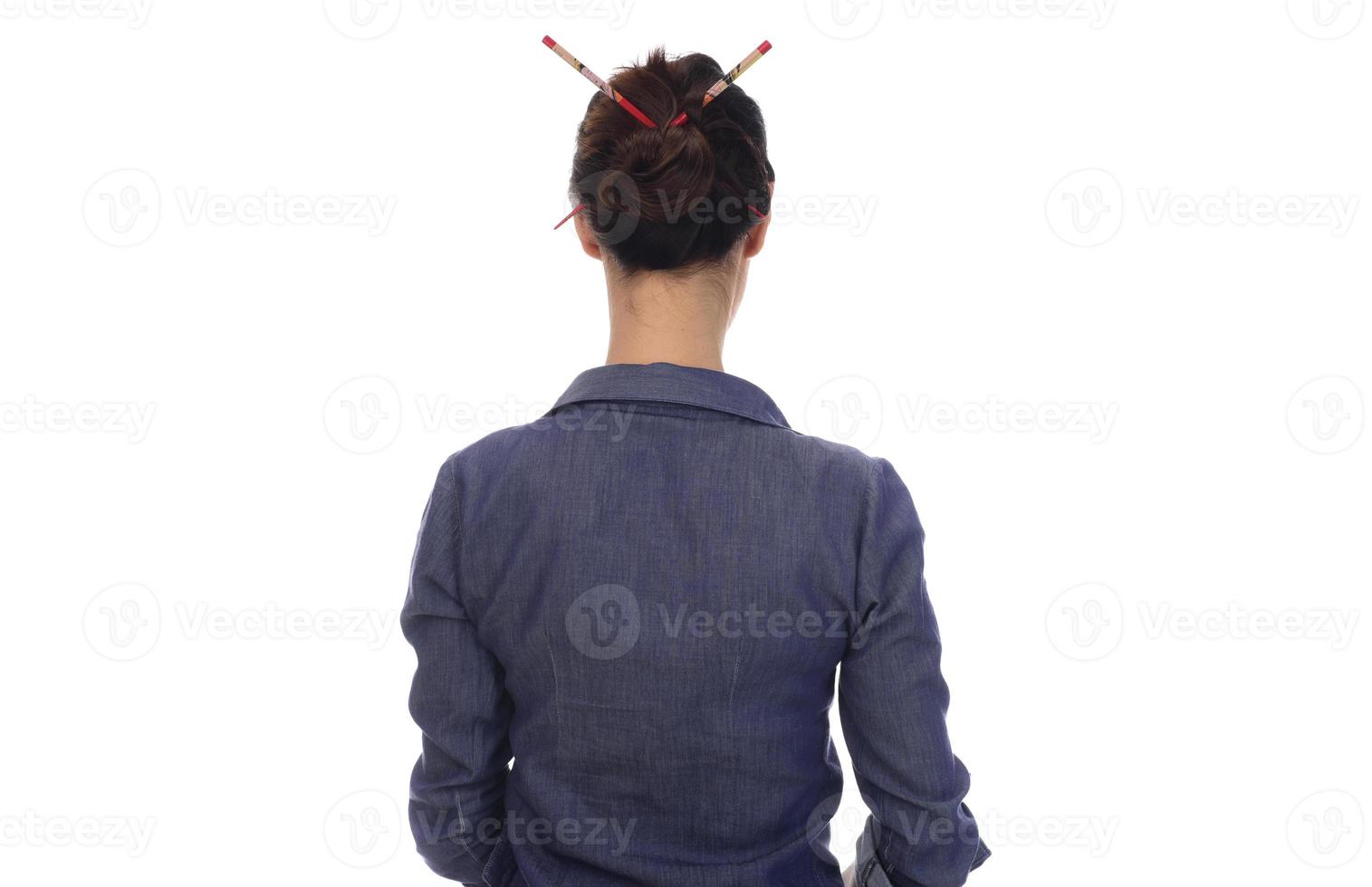 A woman makes a messy hair bun on her head photo