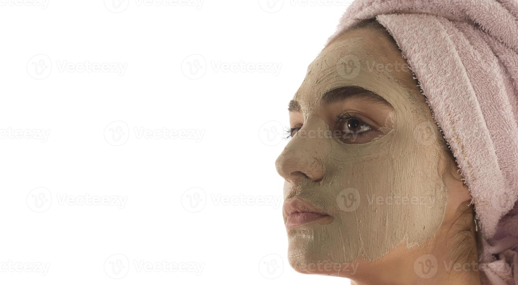 Beauty procedures skin care concept. Young woman applying facial mud clay mask to her face photo