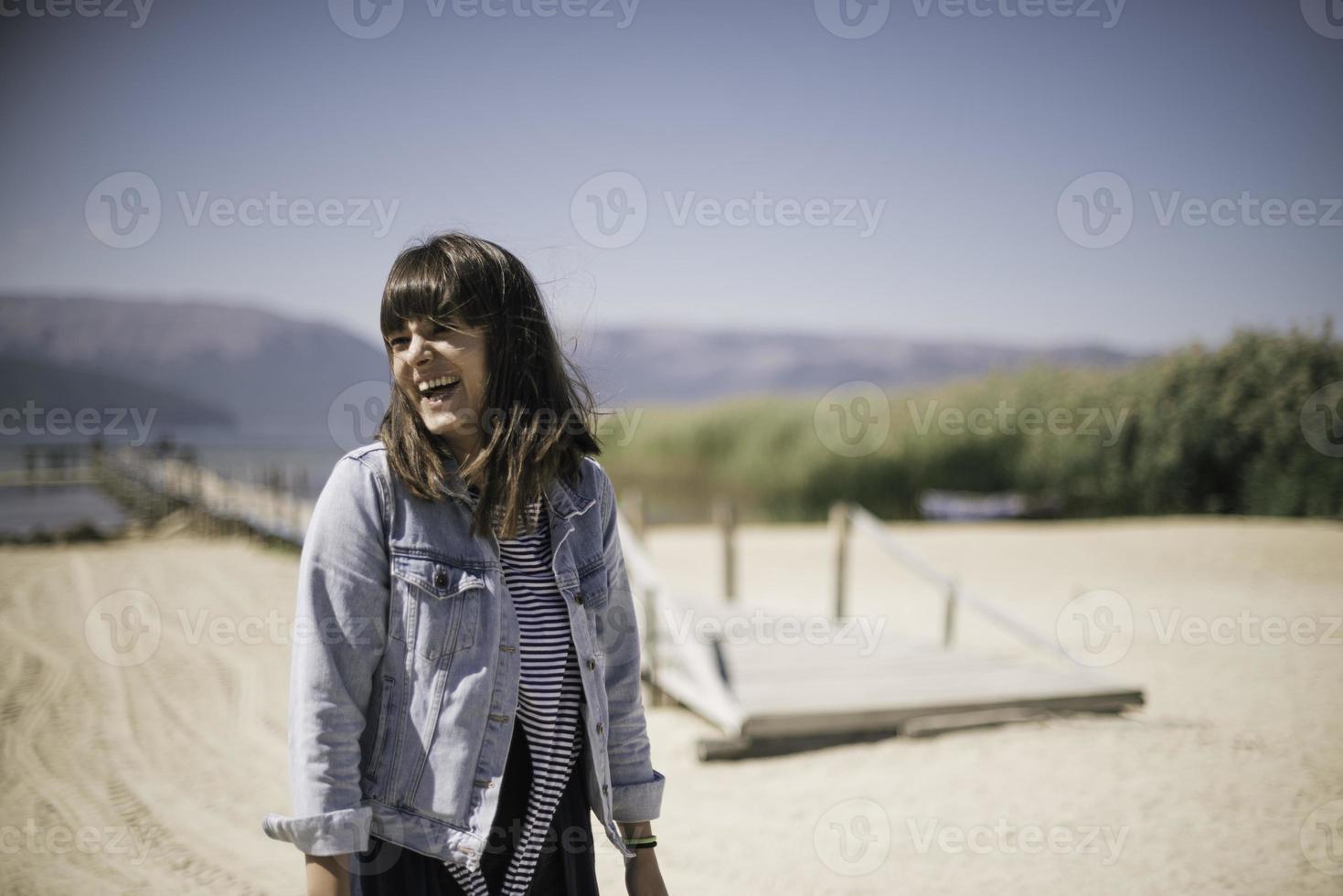 una mujer joven junto a las tranquilas aguas de un lago. foto