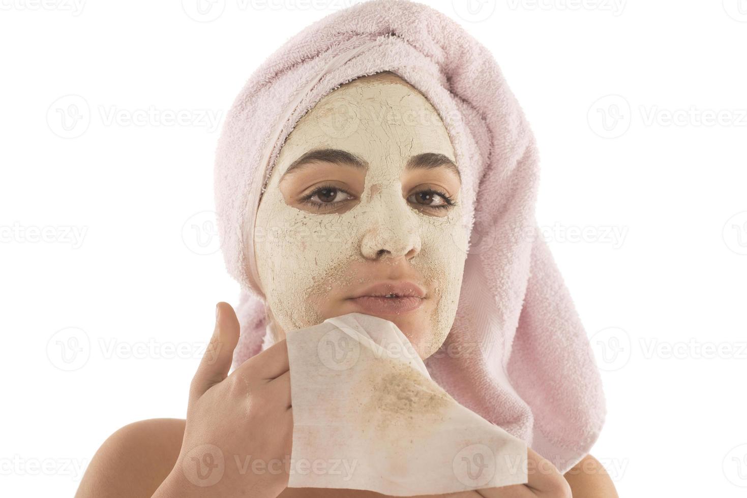 Beauty procedures skin care concept. Young woman applying facial mud clay mask to her face photo