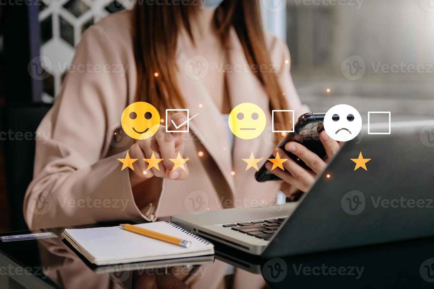 concepto de evaluación del servicio al cliente. mujer de negocios presionando el espectáculo de emoticonos de sonrisa en la pantalla virtual en la tableta y el teléfono inteligente foto