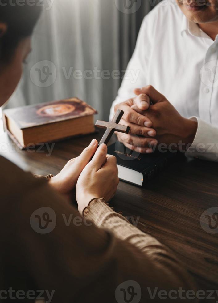 Woman's hand with cross .Concept of hope, faith, christianity, religion, church and pray to God. on the table photo