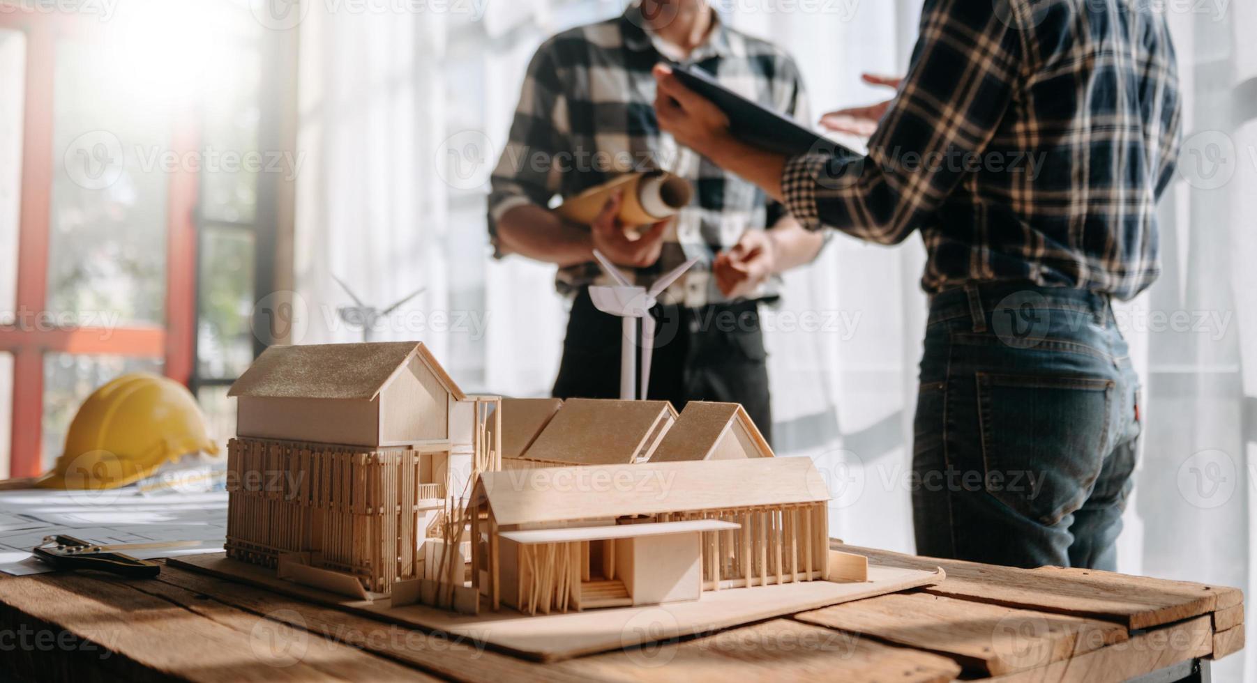 Scale model house on table with architects. Two architects making architectural model in office together. to form a new buildin photo