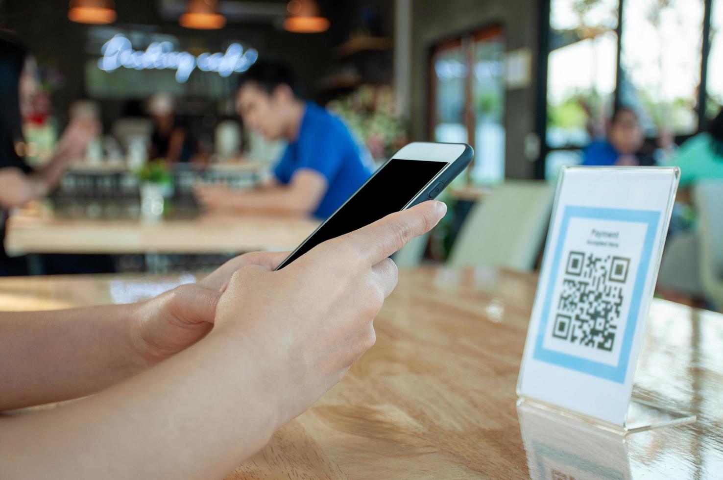 la mujer usa un teléfono inteligente para escanear el código qr para pagar en un café restaurante con un pago digital sin efectivo. elige menú y ordena acumula descuento. billetera electrónica, tecnología, pago en línea, tarjeta de crédito, aplicación bancaria foto