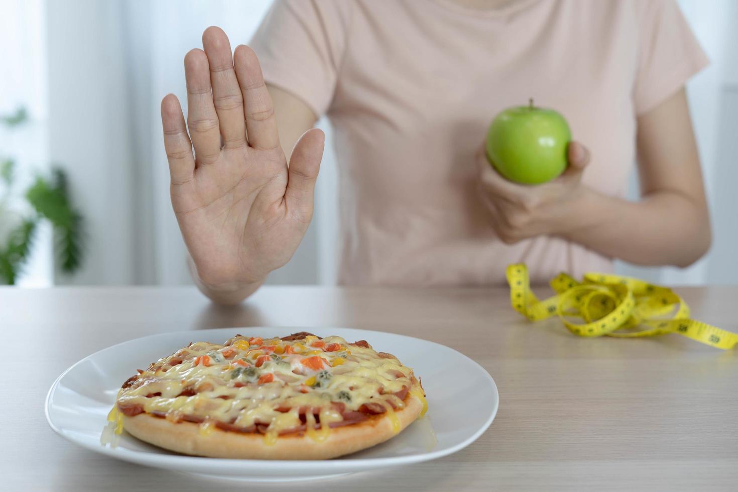 las mujeres de cuerpo delgado eligen durante los alimentos saludables y la comida chatarra, las mujeres eligen manzana verde para la dieta. buena comida saludable. bajar de peso, equilibrar, controlar, reducir grasa, bajar calorías, rutinas, hacer ejercicio. foto