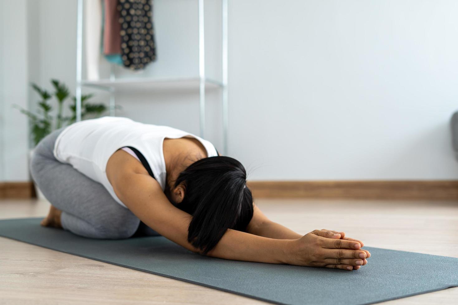 mujer practicando meditar en el parque. mujer asiática haciendo ejercicios por la mañana. equilibrio, recreación, relajación, calma, buena salud, feliz, relajarse, estilo de vida saludable, reducir el estrés, pacífico, actitud foto