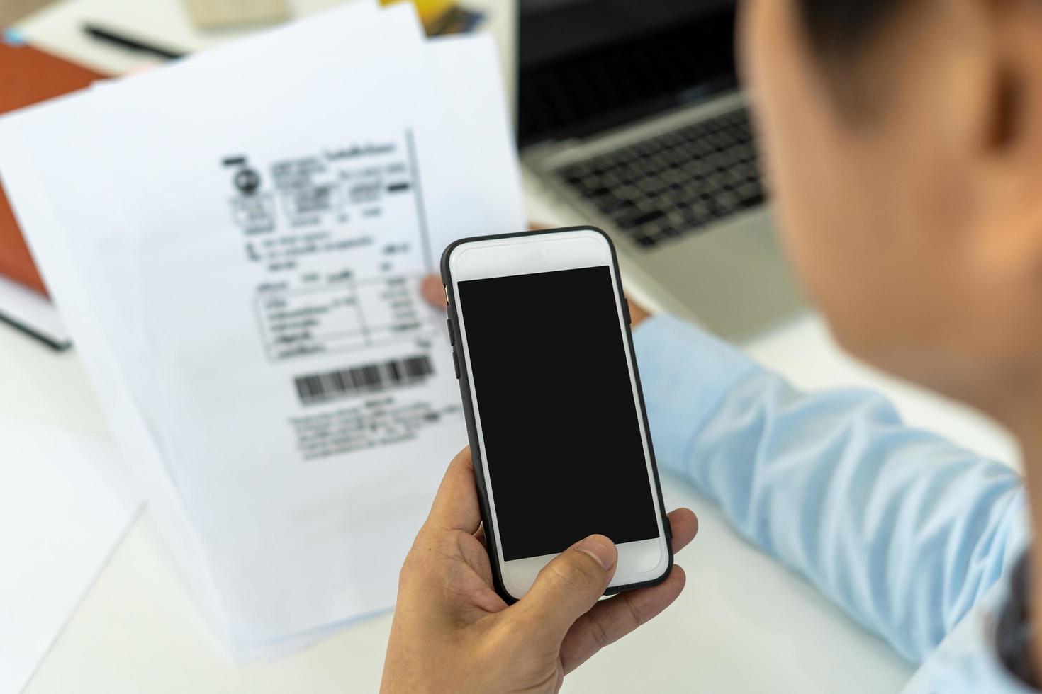 el hombre de negocios usa el teléfono para escanear códigos de barras o códigos qr para pagar la factura de la tarjeta de crédito después de recibir la factura del documento en línea. Págame foto