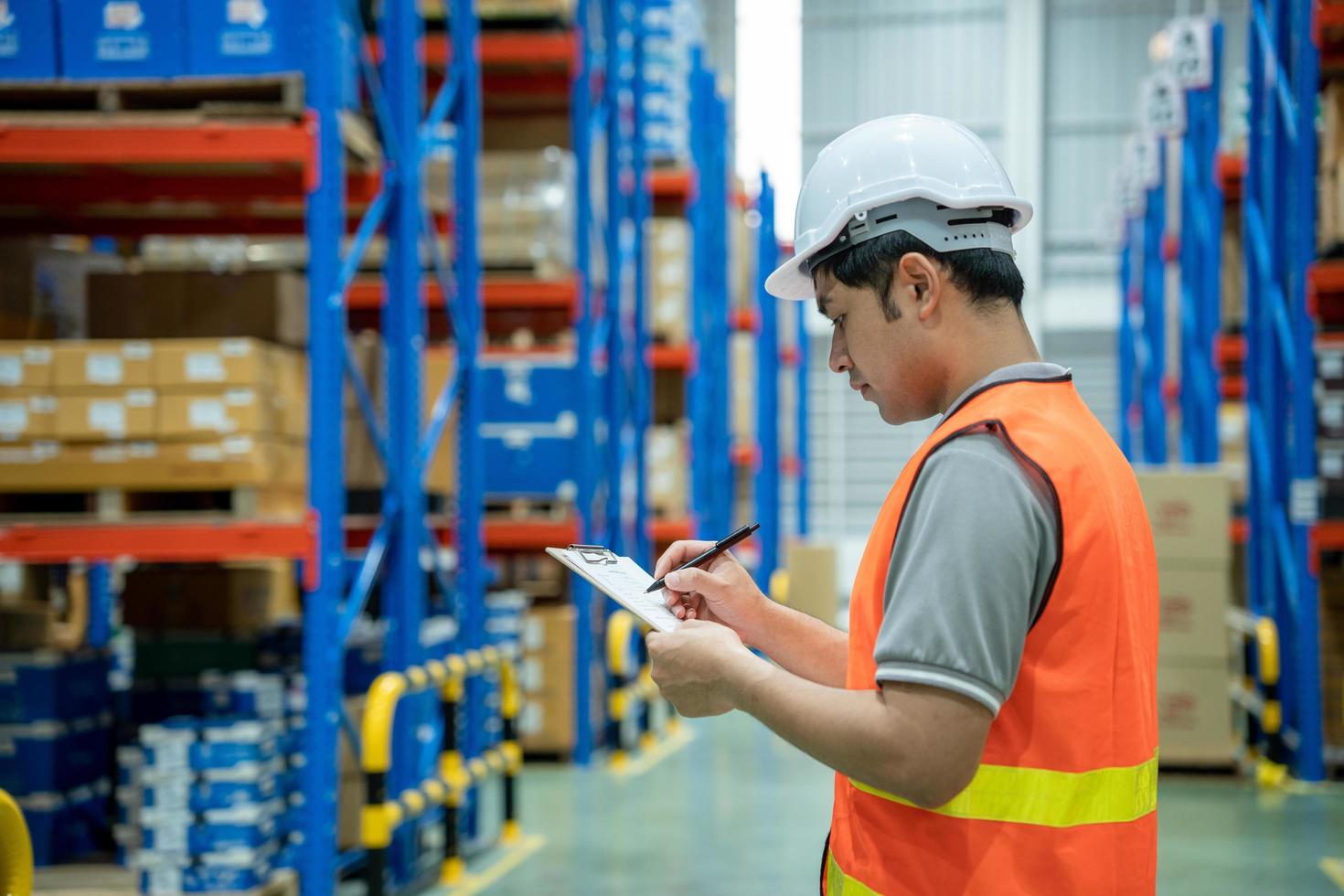 Asian male factory manager inspects the goods in the warehouse and check stock product. Transport logistic business shipping and delivery to customers quickly through a freight forwarding company. photo