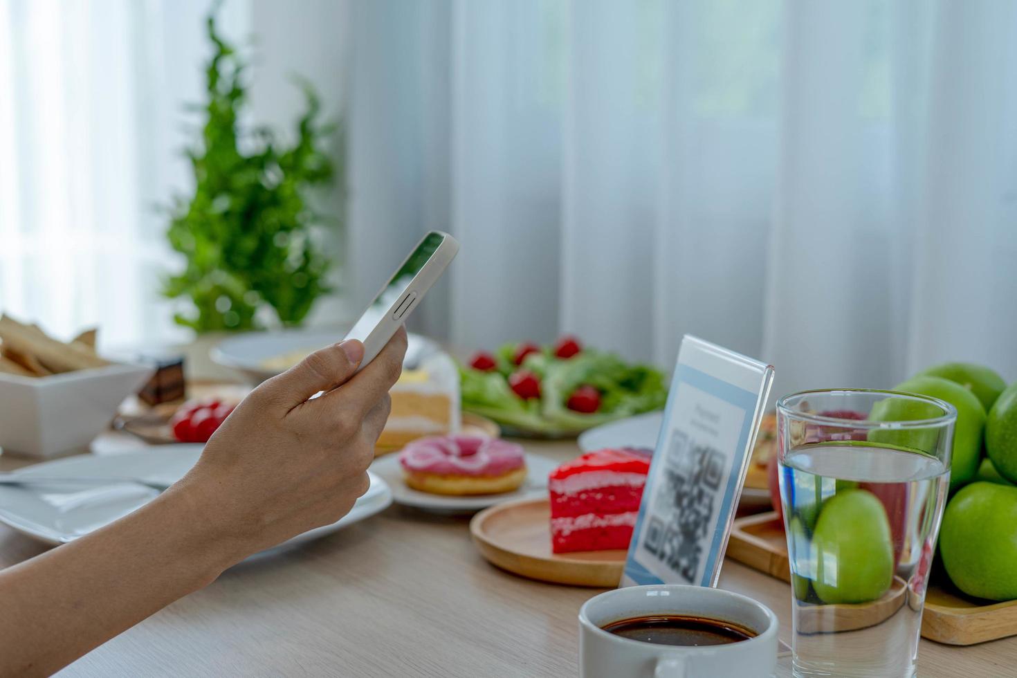 Woman use smartphone to scan QR code to pay in cafe restaurant with a digital payment without cash. Choose menu and order accumulate discount. E wallet, technology, pay online, credit card, bank app photo