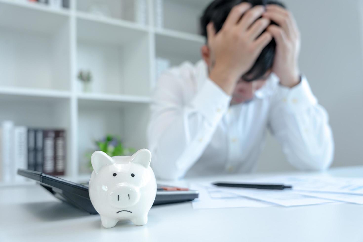 Stressed and headache asian man with large bills or invoices no money to pay to expenses and credit card debt. shortage, Financial problems, mortgage, loan, bankruptcy, bankrupt, poor, empty wallet photo