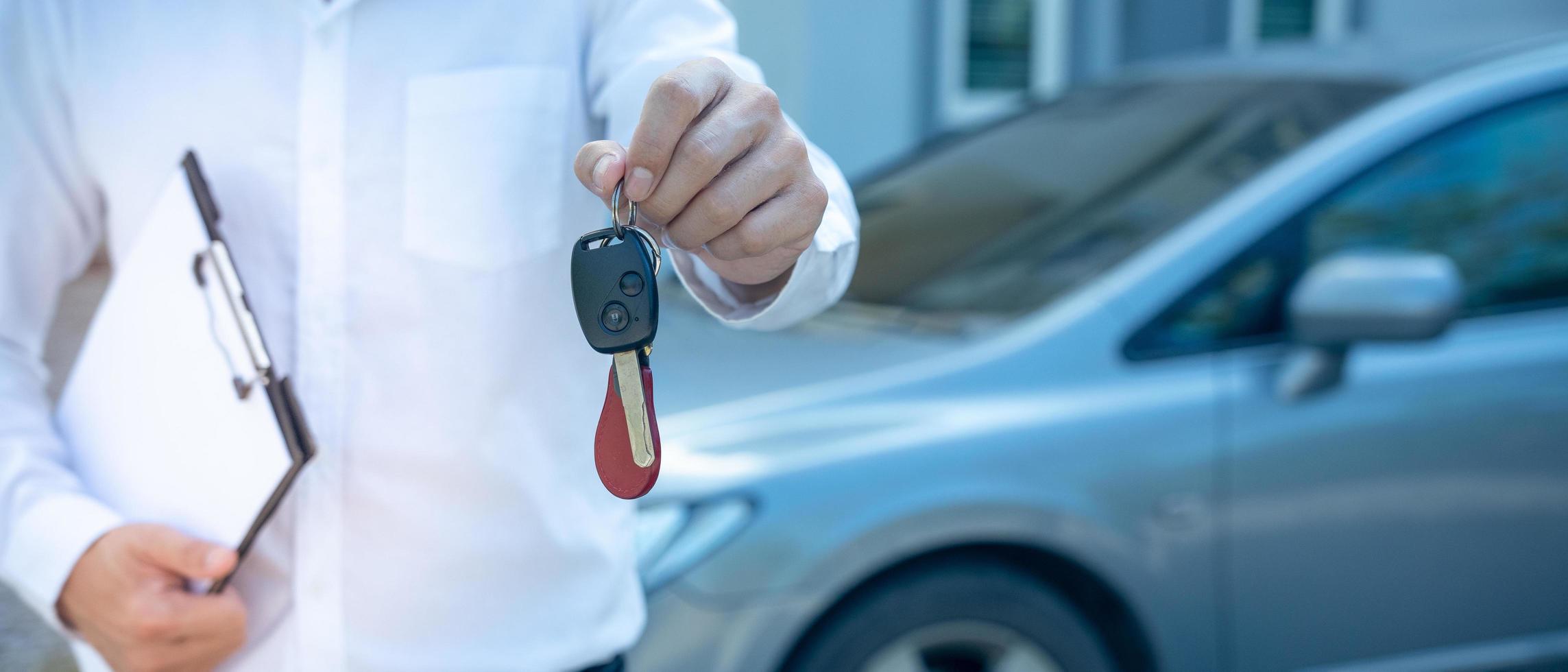 selling car, car sale, deal concept The dealer gives the car keys to the new owner or renter with an insurance contract. banner photo