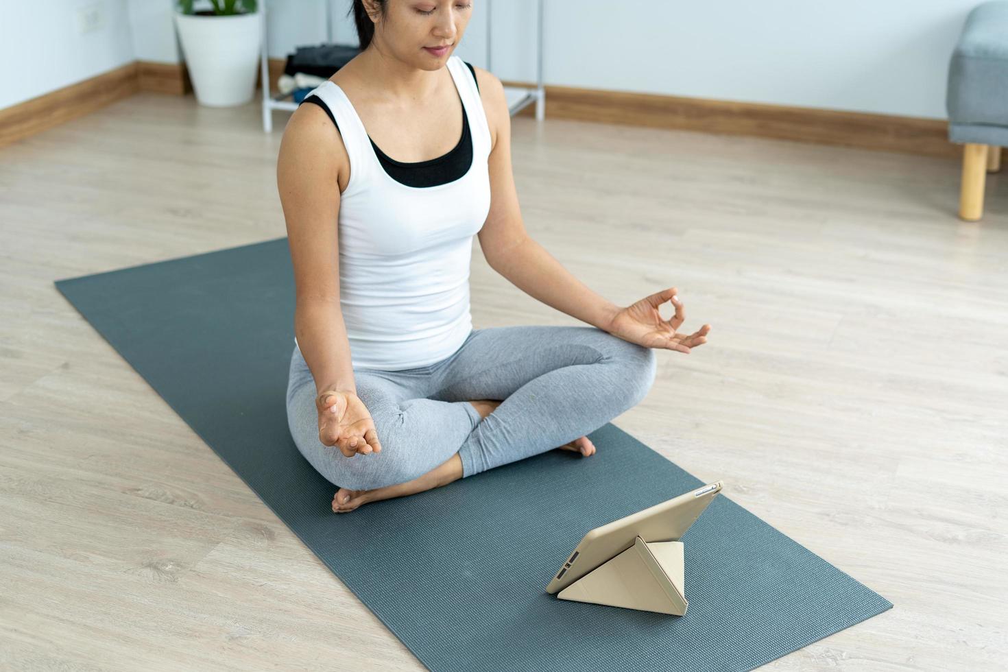 mujer practicando meditar en el parque. mujer asiática haciendo ejercicios por la mañana. equilibrio, recreación, relajación, calma, buena salud, feliz, relajarse, estilo de vida saludable, reducir el estrés, pacífico, actitud foto