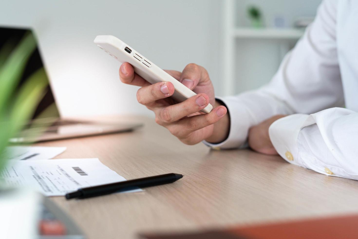 business man use phone to scan barcode or QR codes to pay credit card bill after receiving document invoice online. payment, receive, paying electricity, digital payments without money, technology. photo