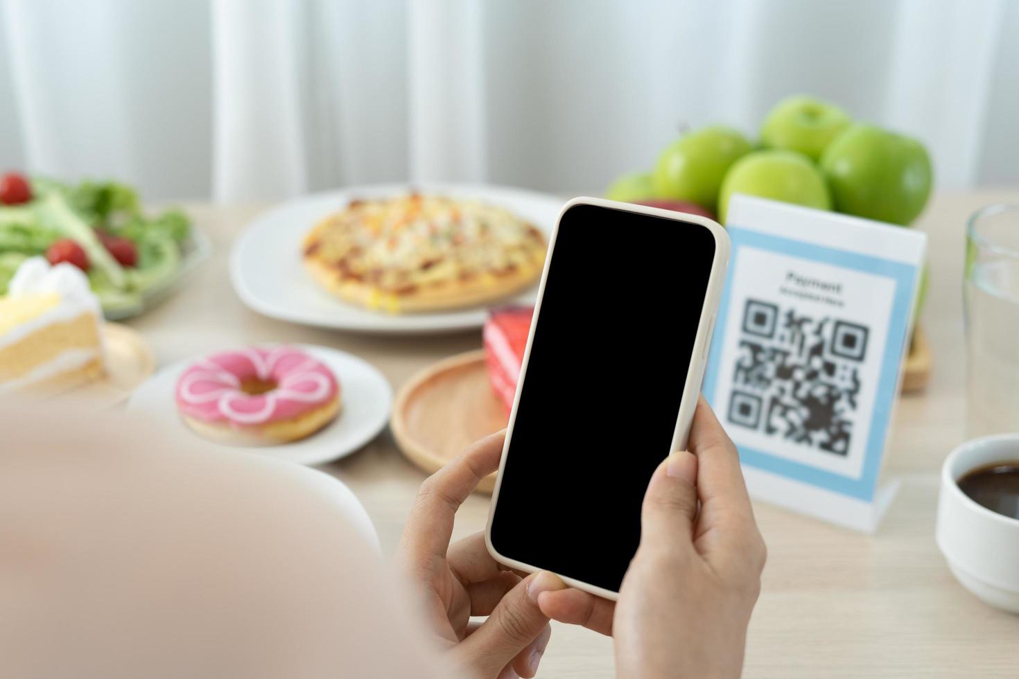 Woman use smartphone to scan QR code to pay in cafe restaurant with a digital payment without cash. Choose menu and order accumulate discount. E wallet, technology, pay online, credit card, bank app photo