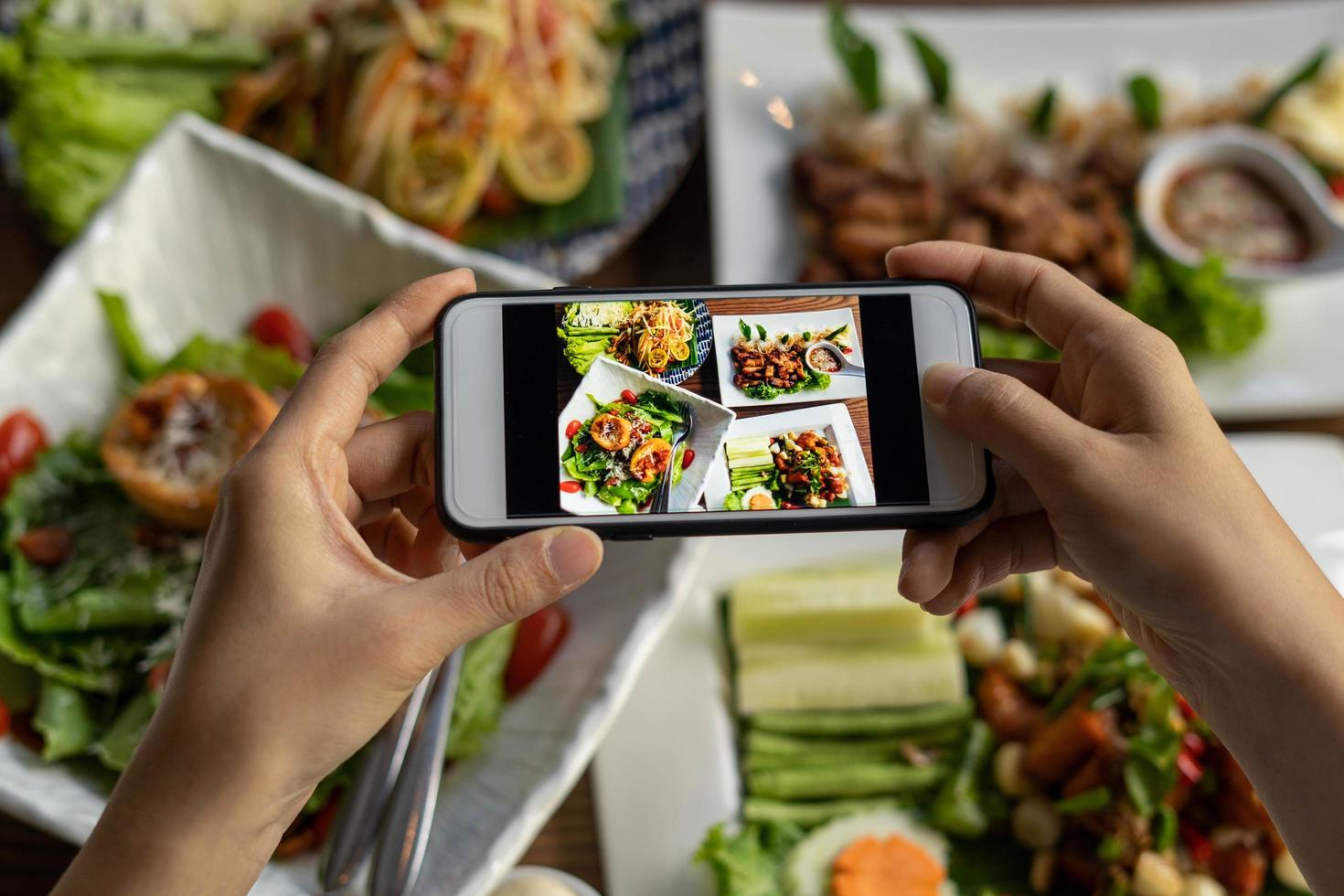 Woman take picture of a meal on the table after ordering food online to eat at home. Photography and use phone concepts photo