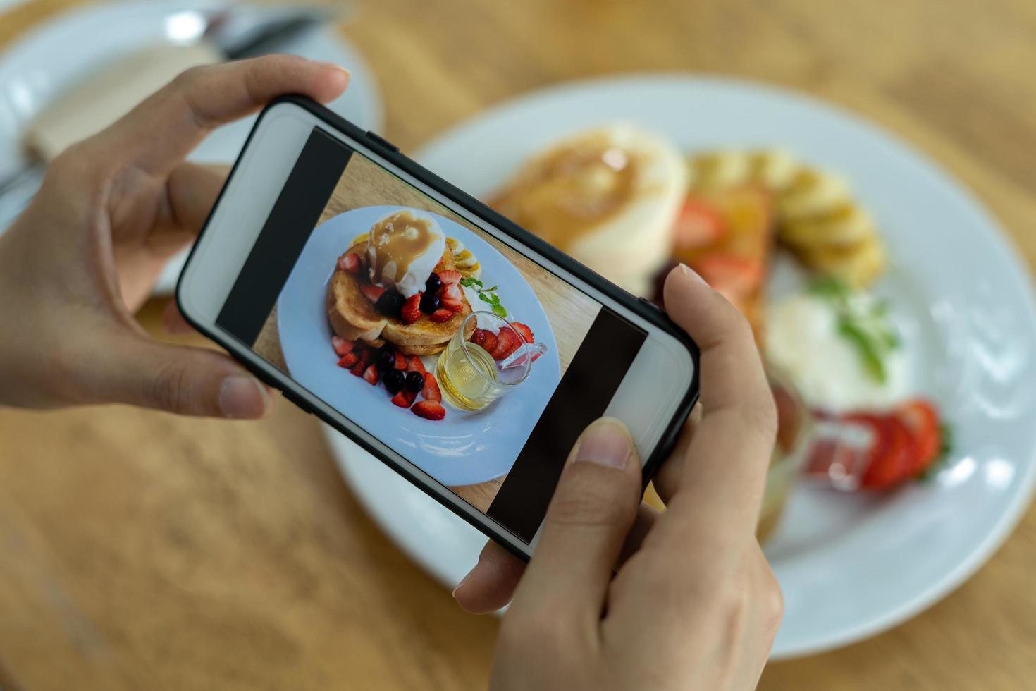 Woman take picture of a meal on the table after ordering food online to eat at home. Photography and use phone concepts photo