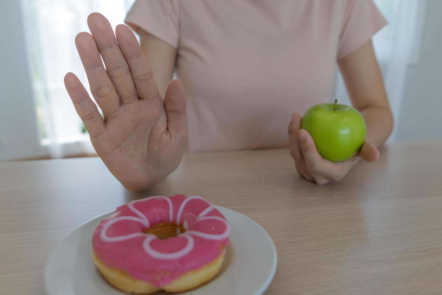 las mujeres de cuerpo delgado eligen durante los alimentos saludables y la comida chatarra, las mujeres eligen manzana verde para la dieta. buena comida saludable. bajar de peso, equilibrar, controlar, reducir grasa, bajar calorías, rutinas, hacer ejercicio. foto