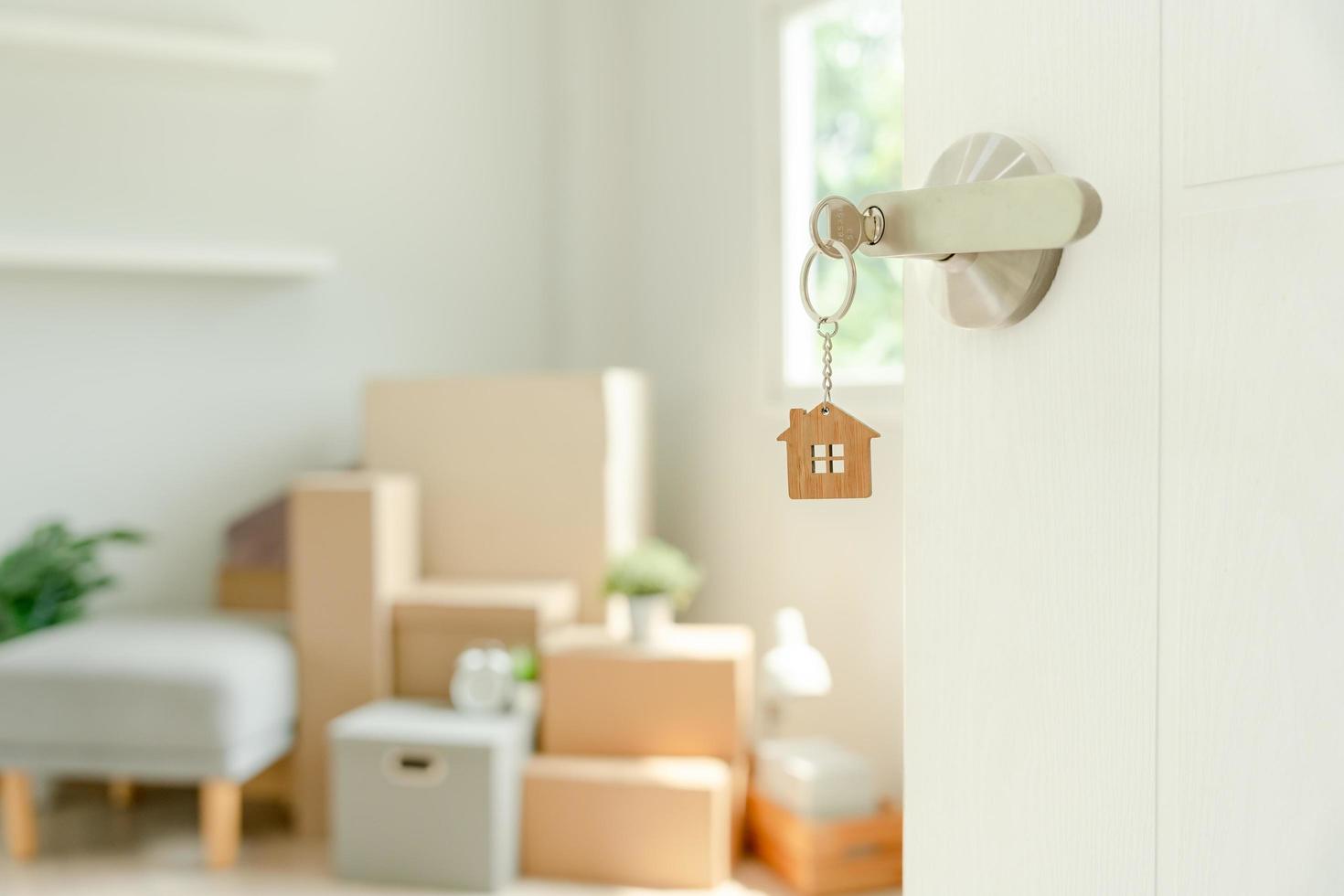 Moving house, relocation.  key house keychain in new apartment, inside the room was a cardboard box containing personal belongings and furniture. move in the apartment or condominium , Second hand photo