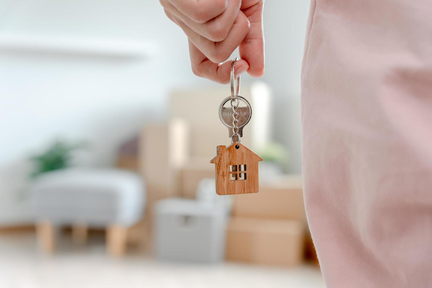 Moving house, relocation. Woman hold key house keychain in new apartment. move in new home. Buy or rent real estate. flat tenancy, leasehold property, new landlord, dwelling, loan, mortgage. photo