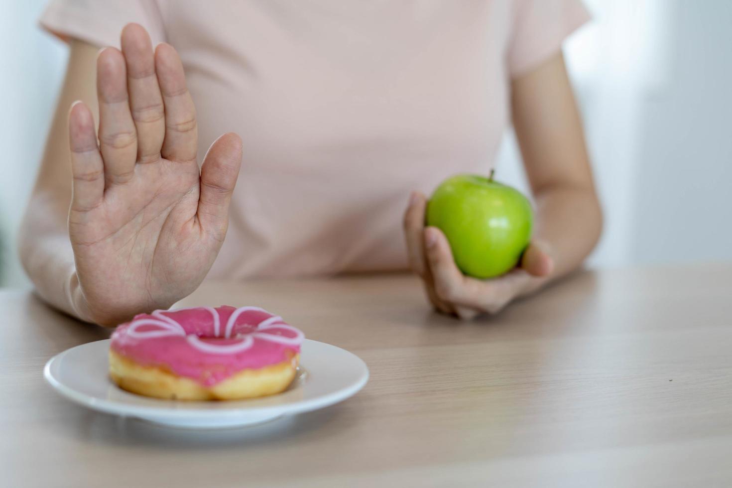 las mujeres de cuerpo delgado eligen durante los alimentos saludables y la comida chatarra, las mujeres eligen manzana verde para la dieta. buena comida saludable. bajar de peso, equilibrar, controlar, reducir grasa, bajar calorías, rutinas, hacer ejercicio. foto