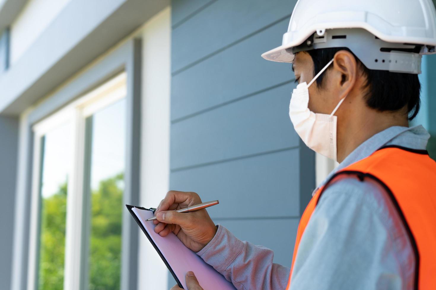 Inspector or engineer is checking and inspecting the building or house by using checklist. Engineers and architects work on building the house before handing it over to the landlord. photo