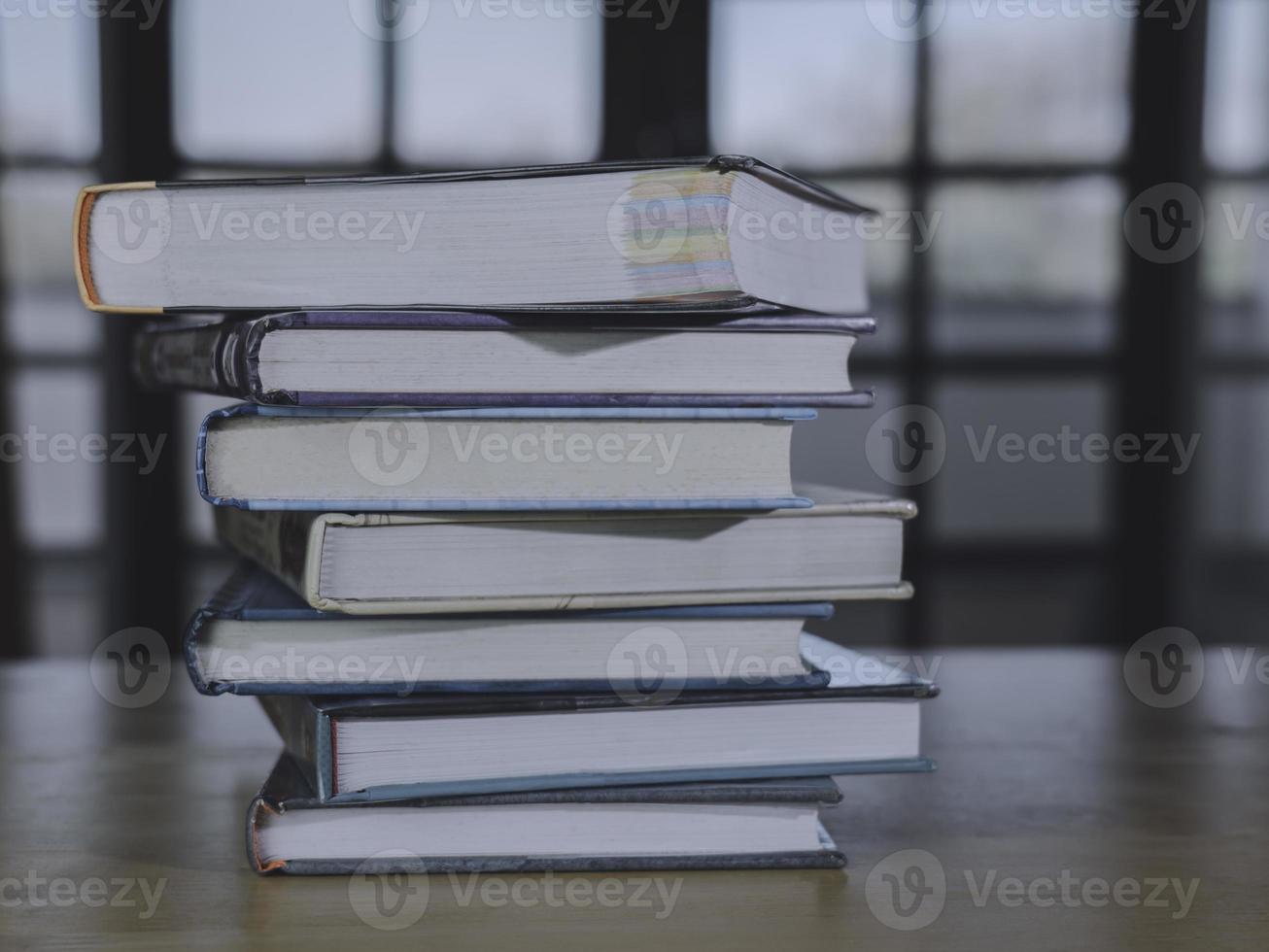 Stack or plie of vintage old books on wooden table. Learning, education and study concept. one of them open with copy space. photo