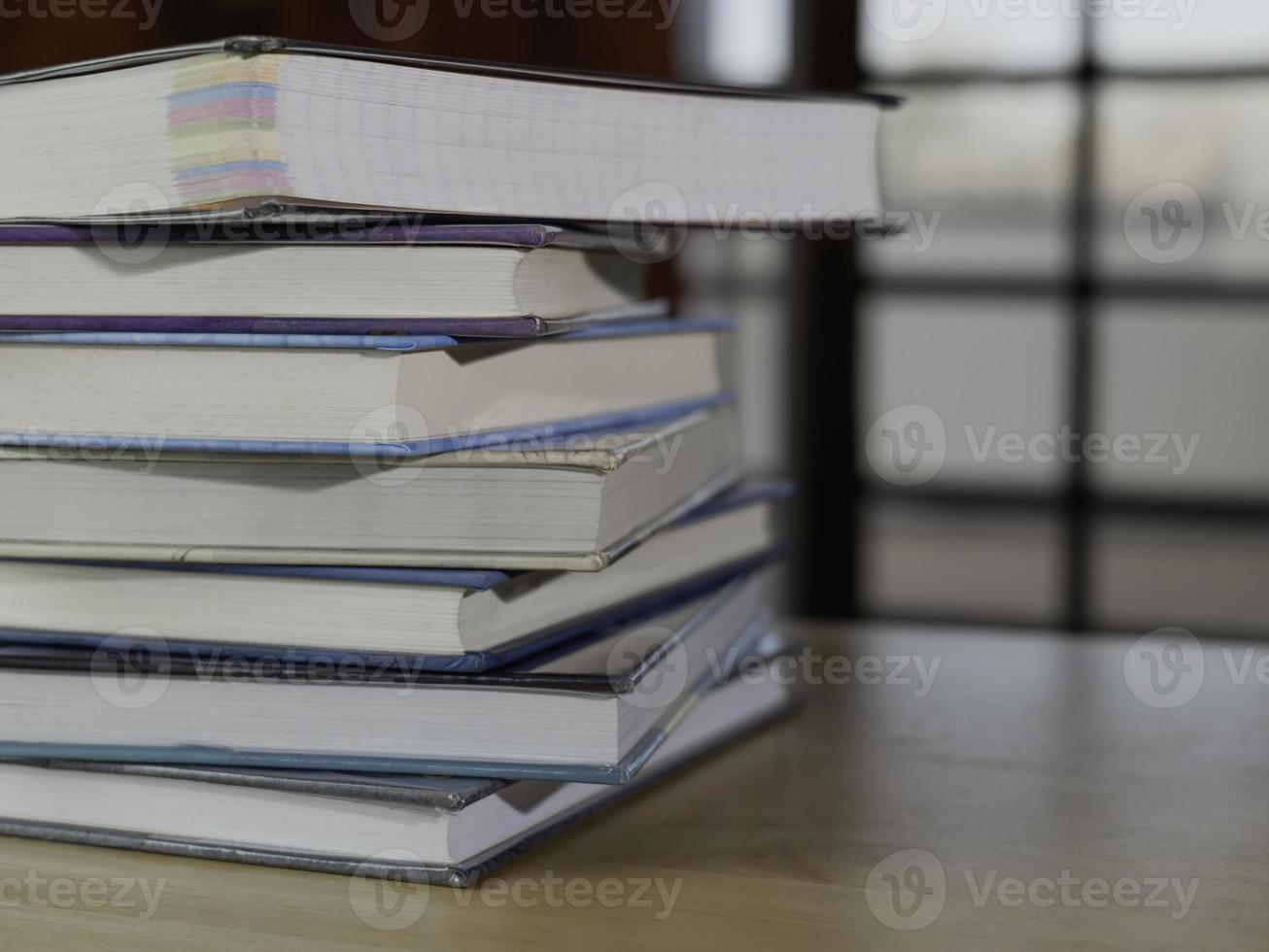 Stack or plie of vintage old books on wooden table. Learning, education and study concept. one of them open with copy space. photo