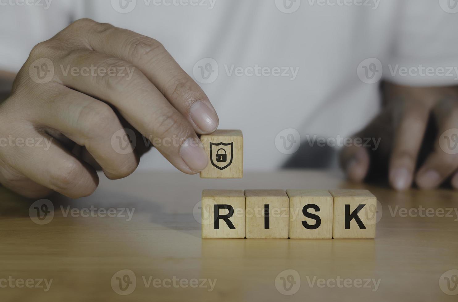 Closeup wooden block written RISK icon for management concept. Hand of business choosing shield icon for protect bussiness and successful winner concept. photo