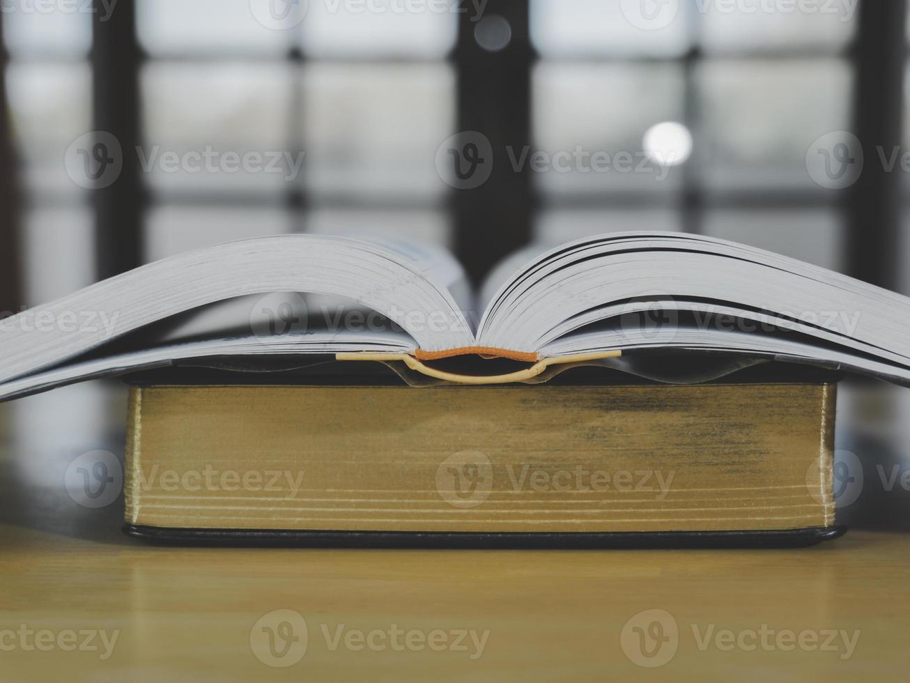 pila o capa de libros antiguos antiguos sobre una mesa de madera. concepto de aprendizaje, educación y estudio. uno de ellos abierto con espacio de copia. foto