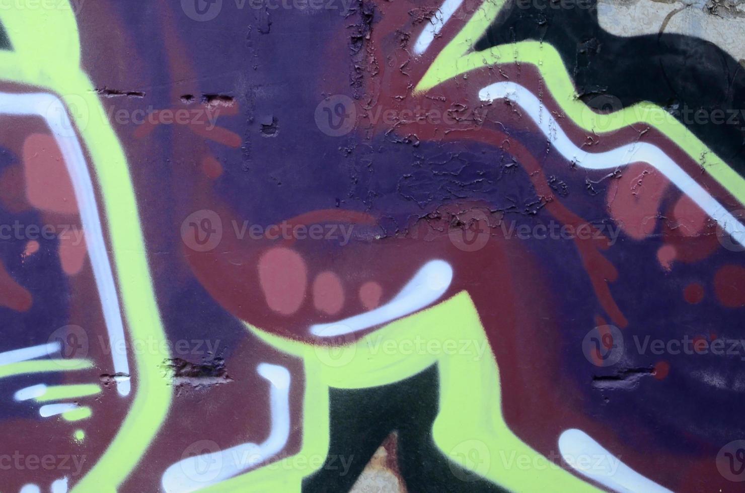Fragment of graffiti drawings. The old wall decorated with paint stains in the style of street art culture. Colored background texture photo