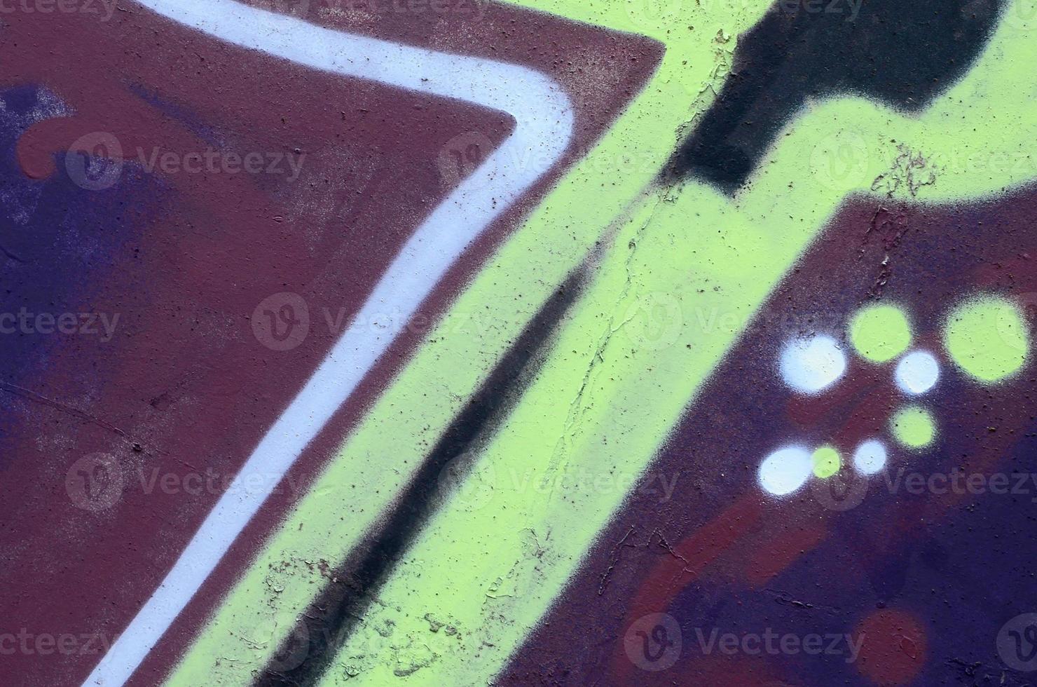 Fragment of graffiti drawings. The old wall decorated with paint stains in the style of street art culture. Colored background texture photo