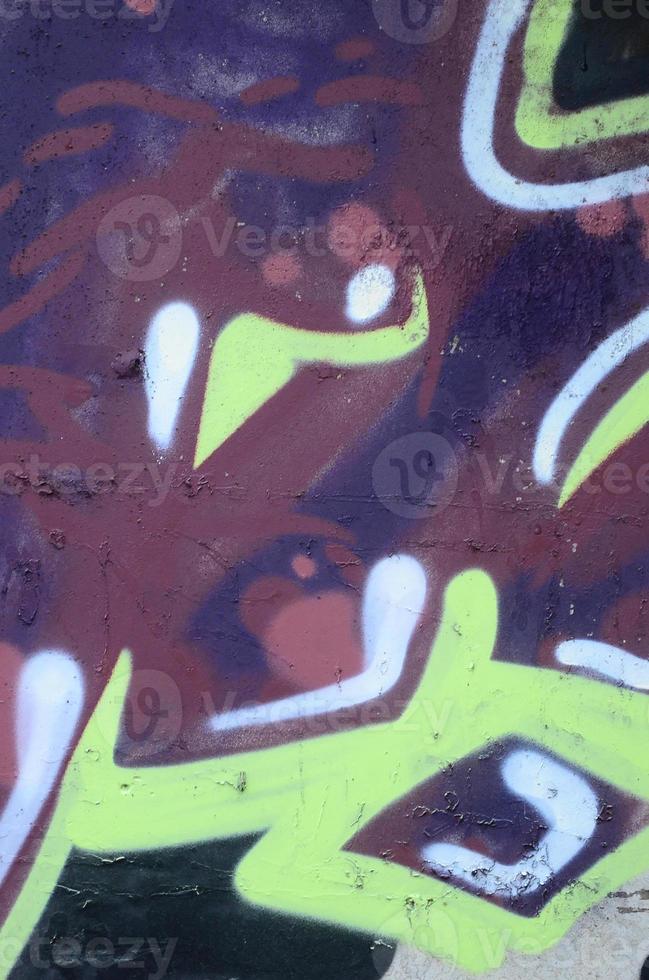 Fragment of graffiti drawings. The old wall decorated with paint stains in the style of street art culture. Colored background texture photo