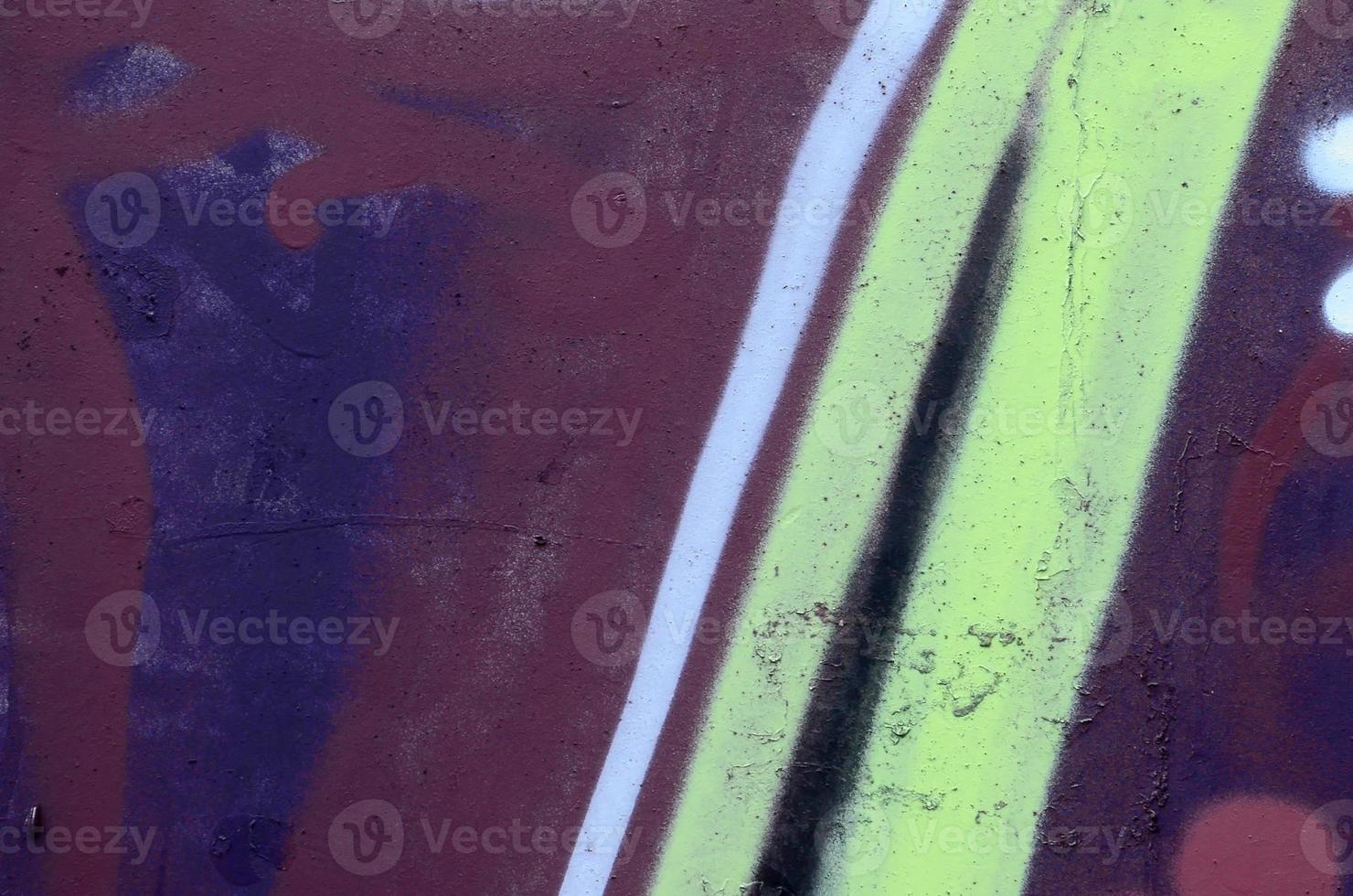 Fragment of graffiti drawings. The old wall decorated with paint stains in the style of street art culture. Colored background texture photo