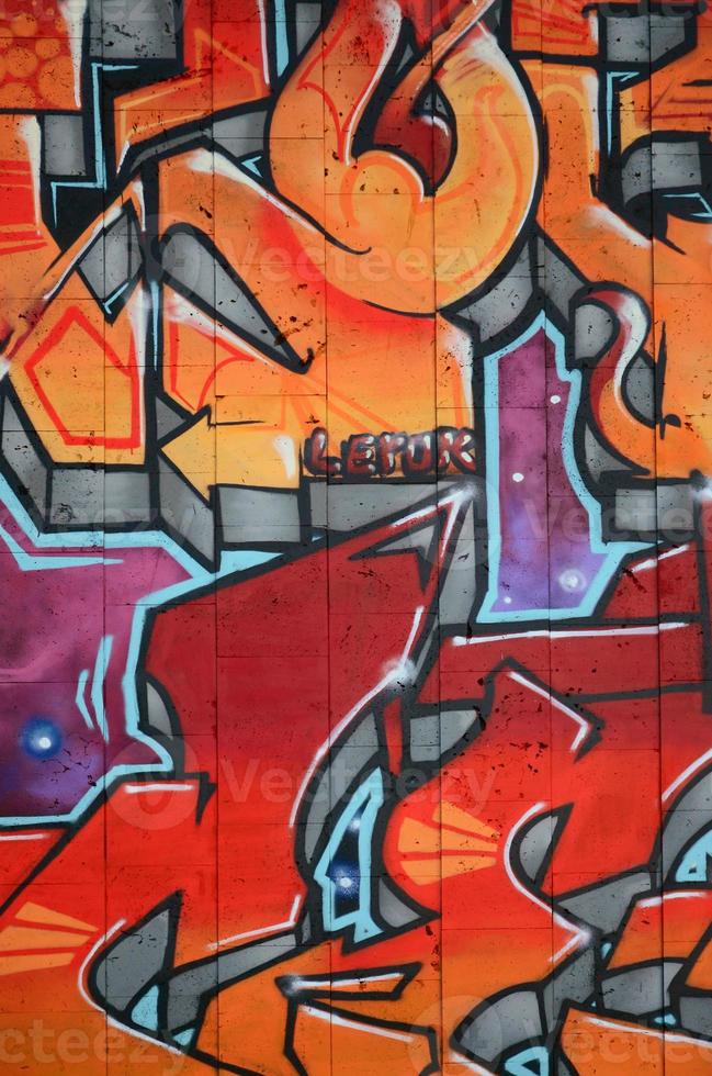 A fragment of detailed graffiti of a drawing made with aerosol paints on a wall of concrete tiles. Background image of street art in warm red color tones photo