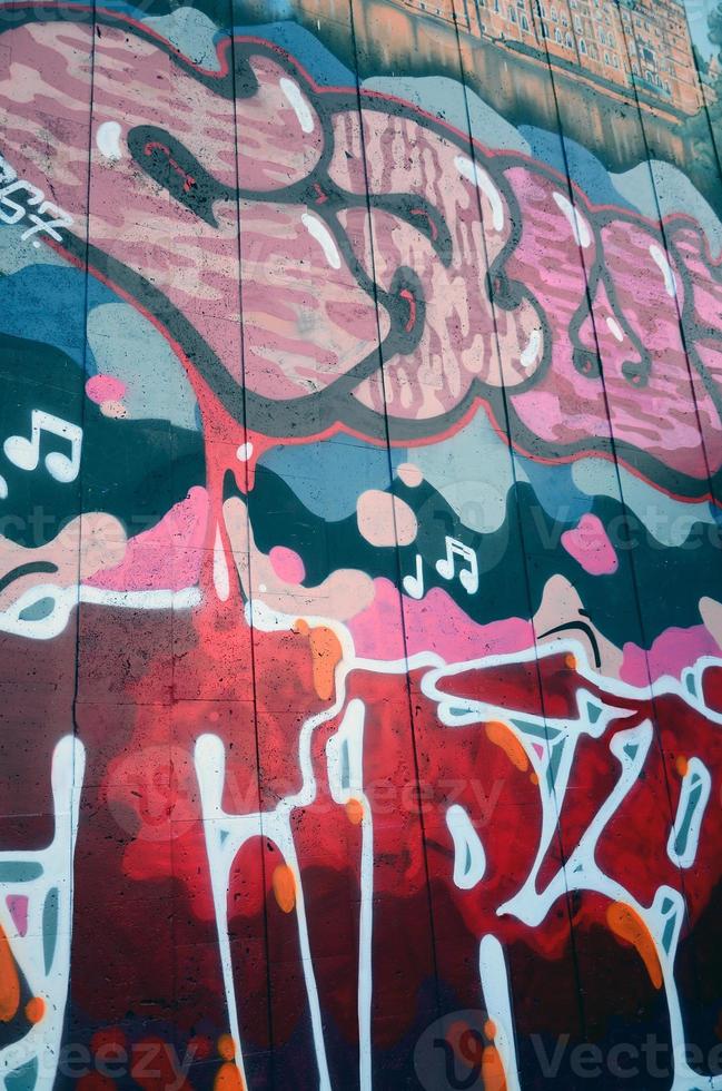 A fragment of detailed graffiti of a drawing made with aerosol paints on a wall of concrete tiles. Background image of street art in warm red color tones photo