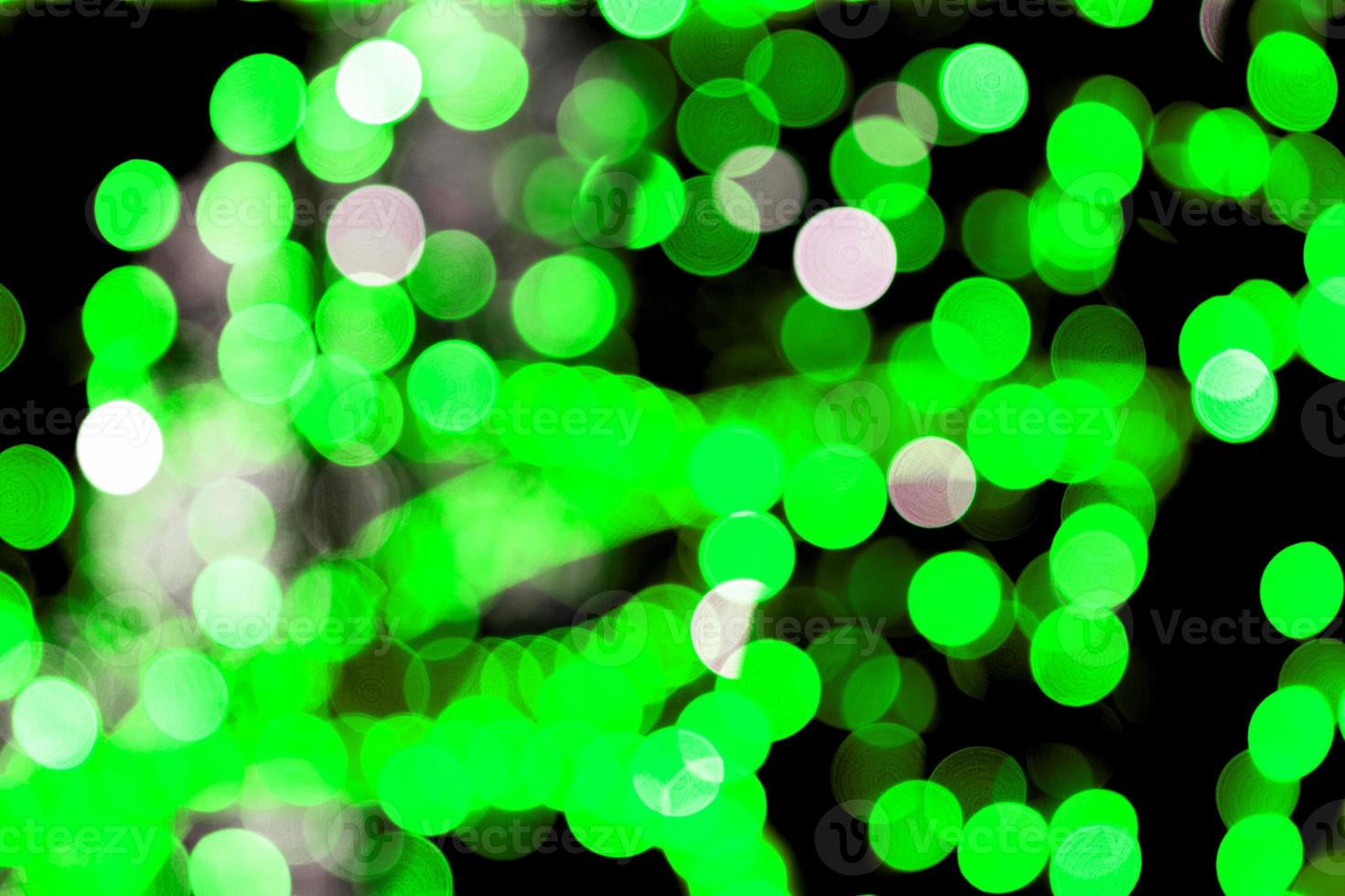 Unfocused abstract colourful bokeh black background. defocused and blurred many round green light photo