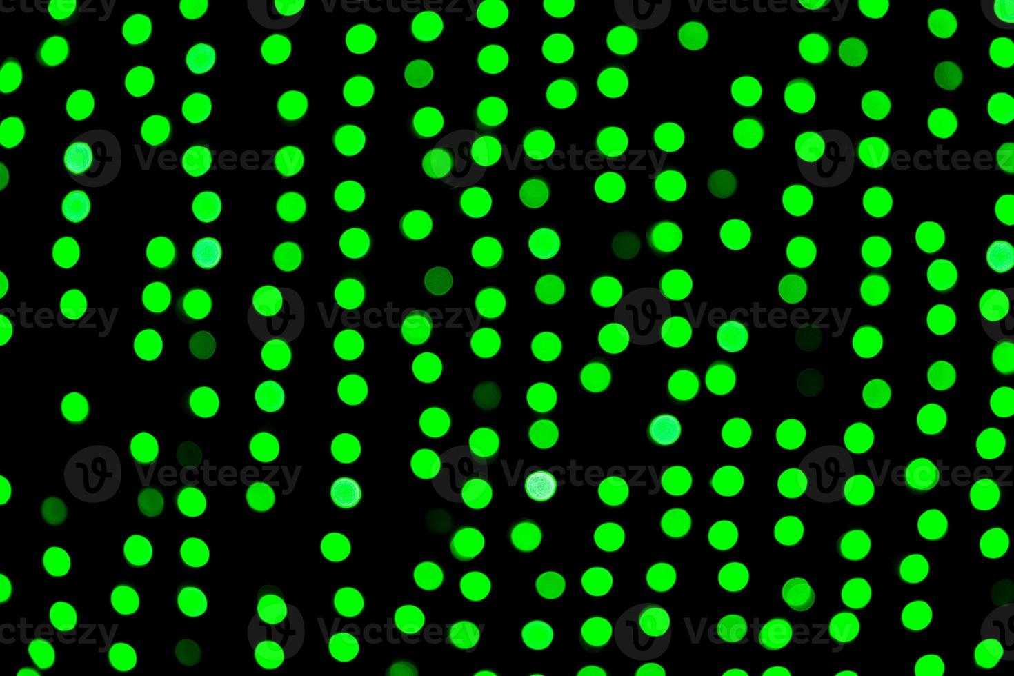 Unfocused abstract green bokeh on black background. defocused and blurred many round light photo