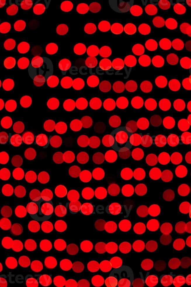 Unfocused abstract red bokeh on black background. defocused and blurred many round light photo