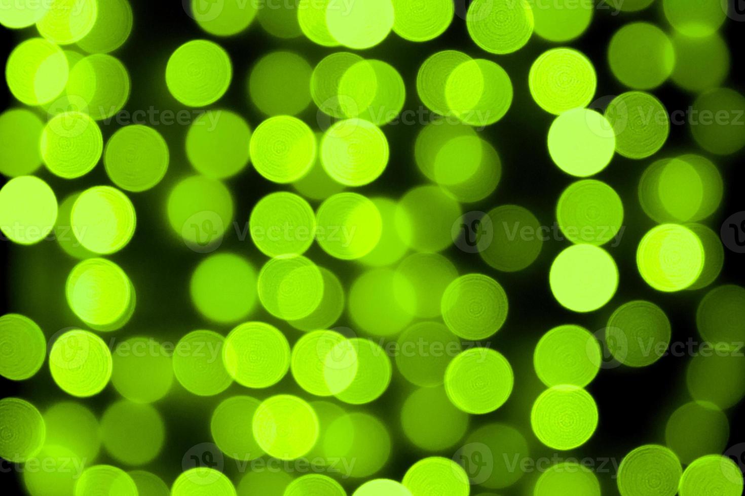 Unfocused abstract colourful bokeh black background. defocused and blurred many round green light photo