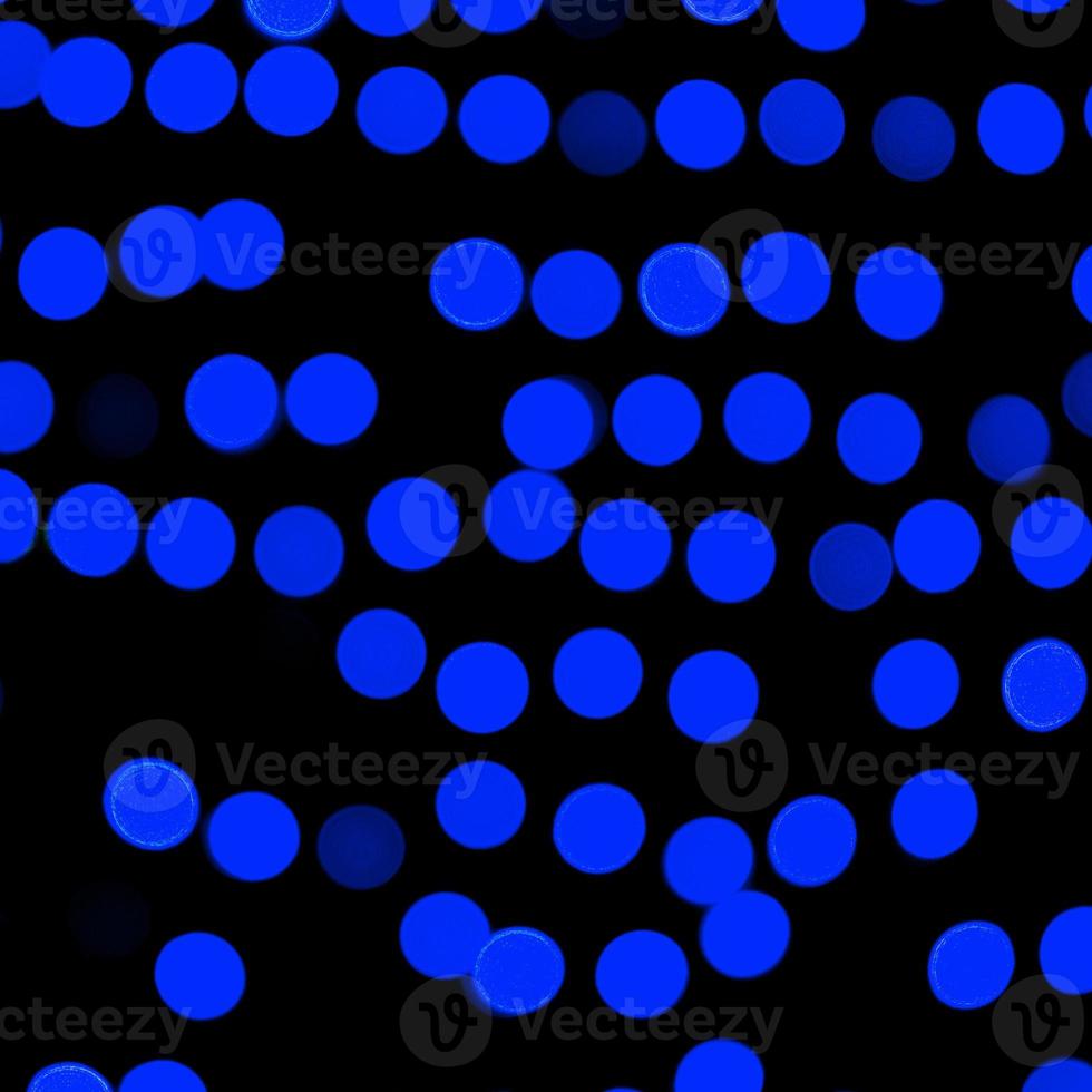 Unfocused abstract dark blue bokeh on black background. defocused and blurred many round light photo