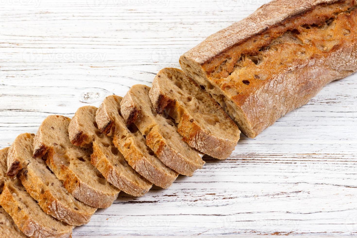 French bread, Baguette sliced on chopping board photo