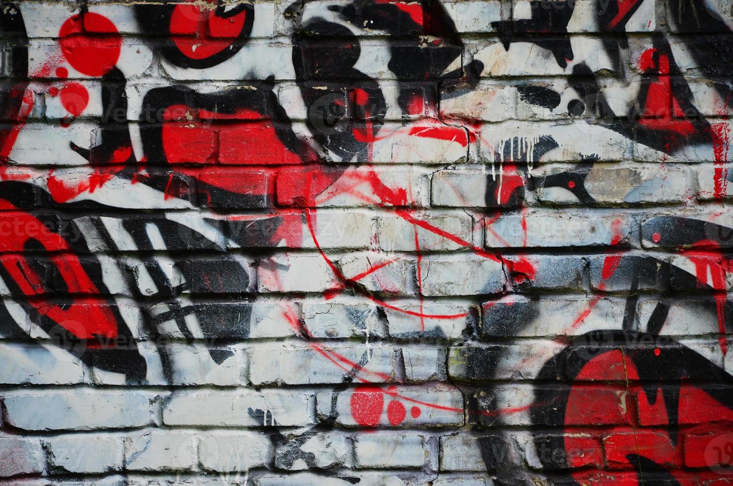 Some elements of a large and composite graffiti pattern on the wall, made with different colors of aerosol paints photo