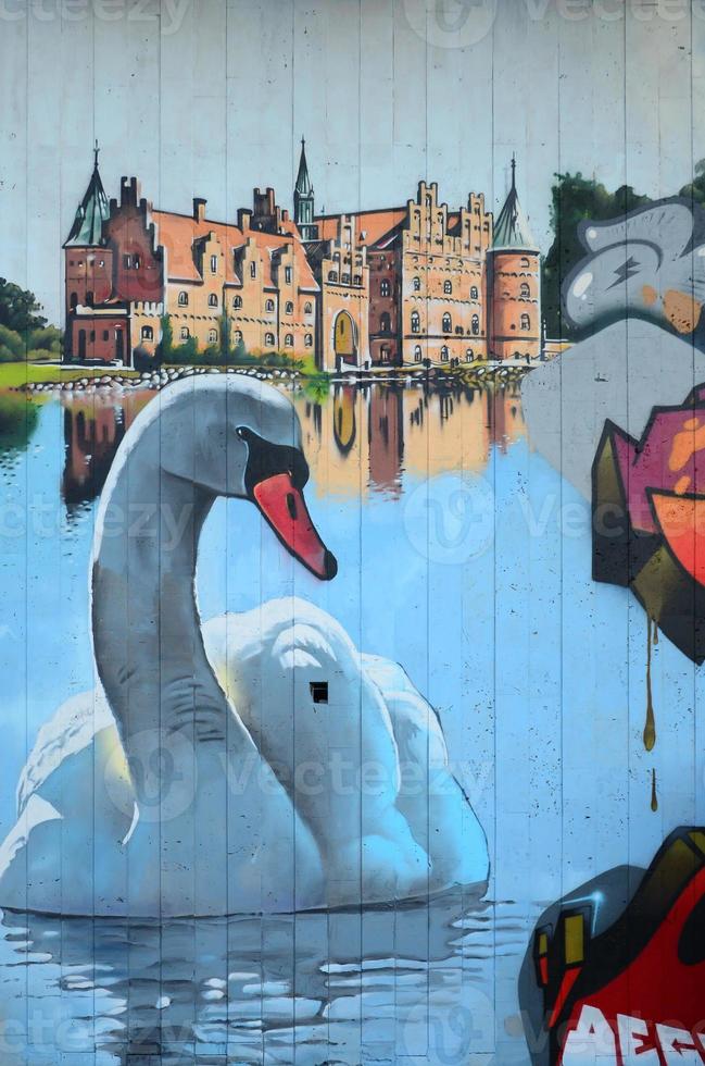 A fragment of detailed graffiti of a drawing made with aerosol paints on a wall of concrete tiles. Background image of street art with a huge white swan photo