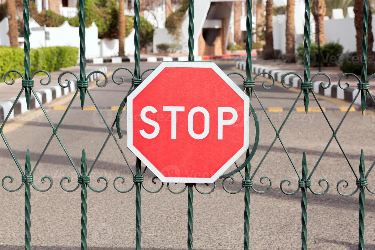 closed gate with a red stop sign at the entrance to the hotel photo