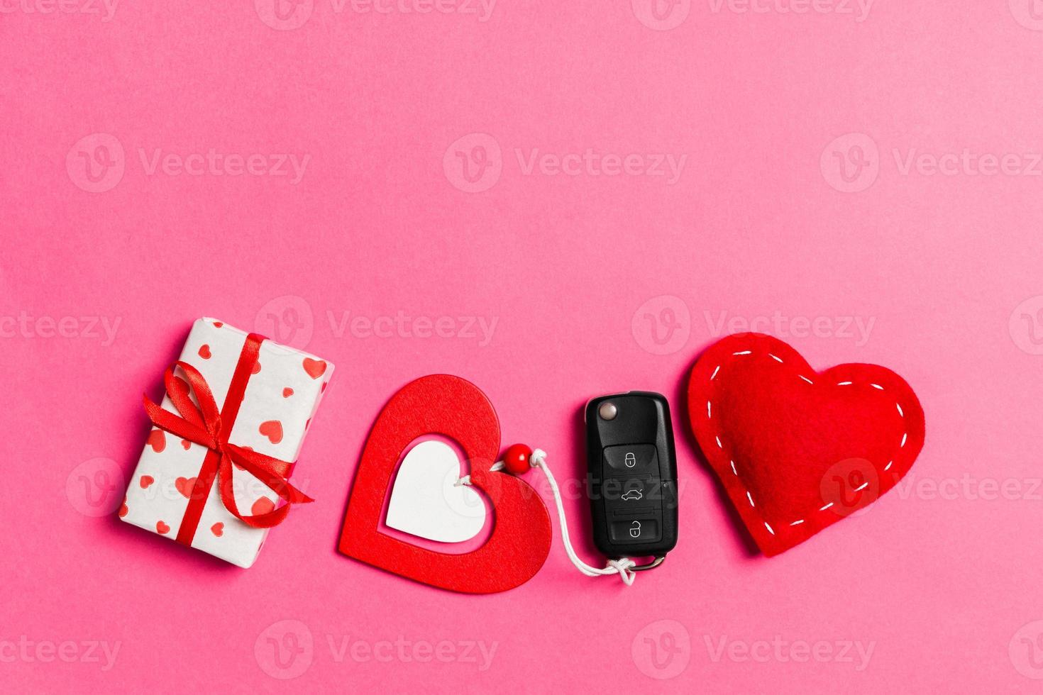 Top view of car key, gift boxes and toy hearts on colorful background. Saint Valentine's Day concept with copy space photo