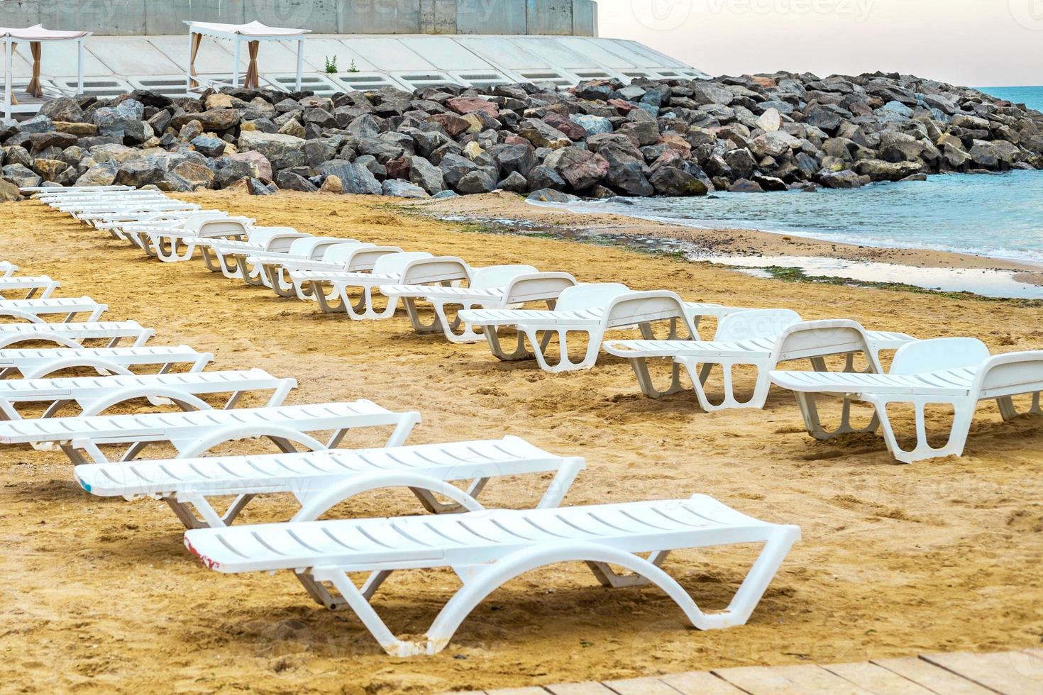 White sunbed on the sand beach at the sea, summer sea rest concept. photo